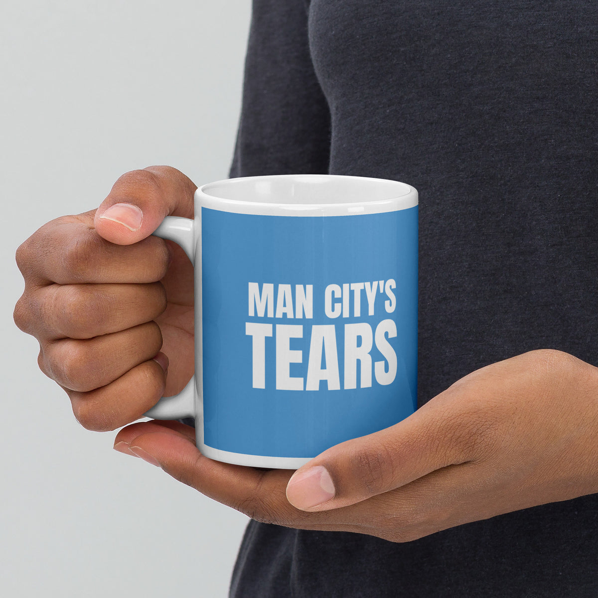 MAN CITY'S TEARS mug passed between two hands